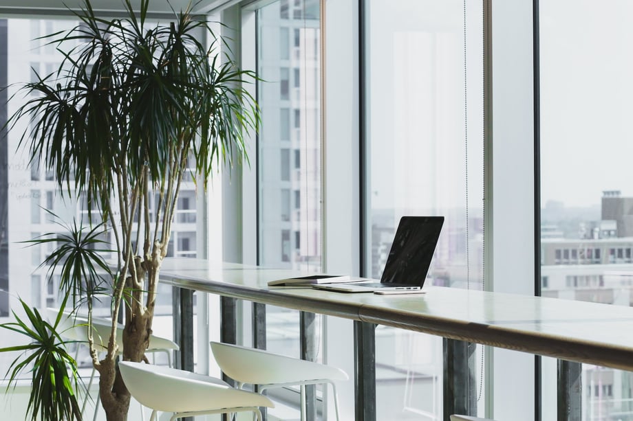 laptop on a desk near a window